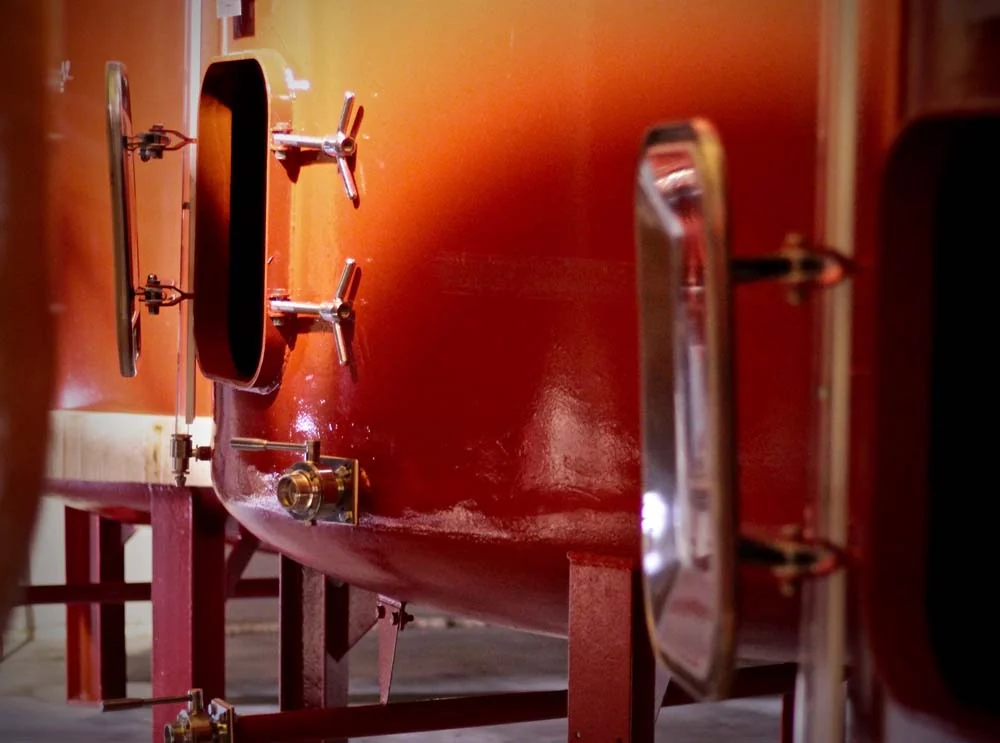 Cuves de fermentation rouge-orange du chai. Graphique.