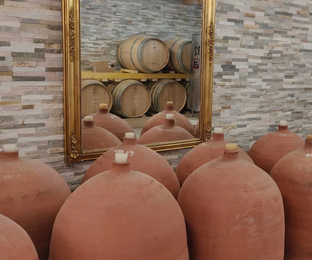 Amphores en terre cuite gravees devant un miroir dore. Vinification en amphore.